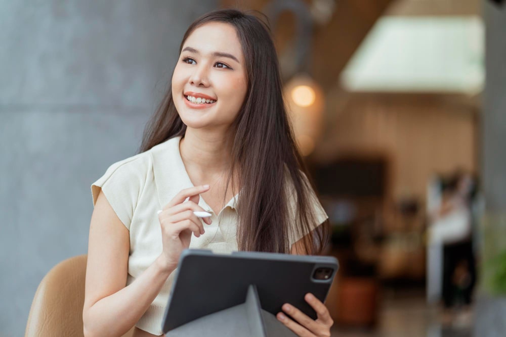 Female freelancer brainstorming how to start a side hustle with tablet